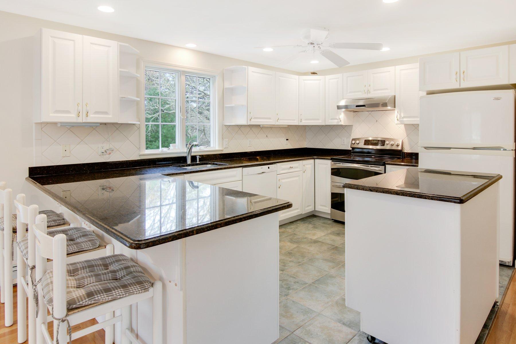 230 Chippingstone Road Chatham, MA 02633 - Photo 21 of 38 a kitchen with kitchen island a sink stove and cabinets