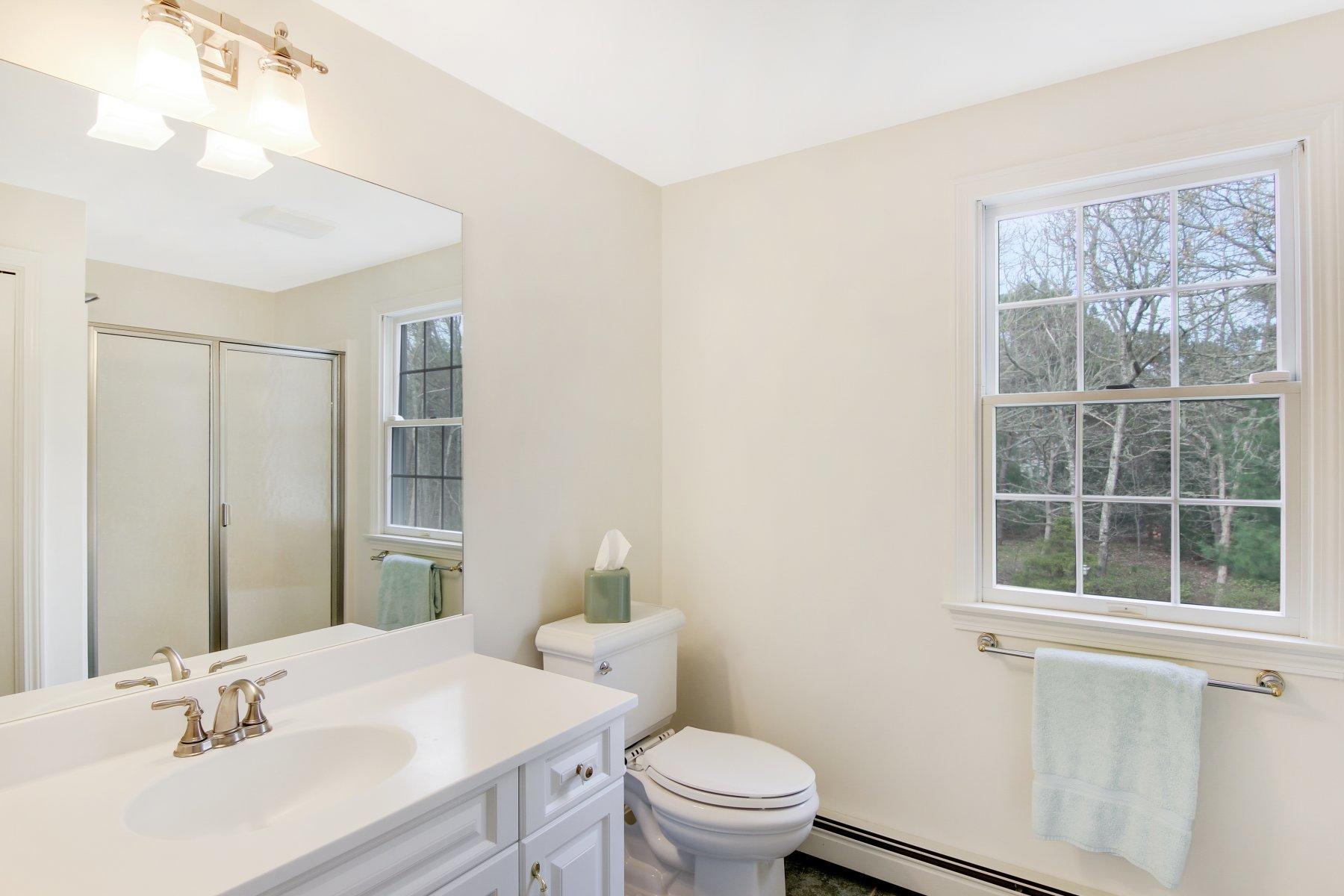 230 Chippingstone Road Chatham, MA 02633 - Photo 26 of 38 a bathroom with a sink toilet vanity and window