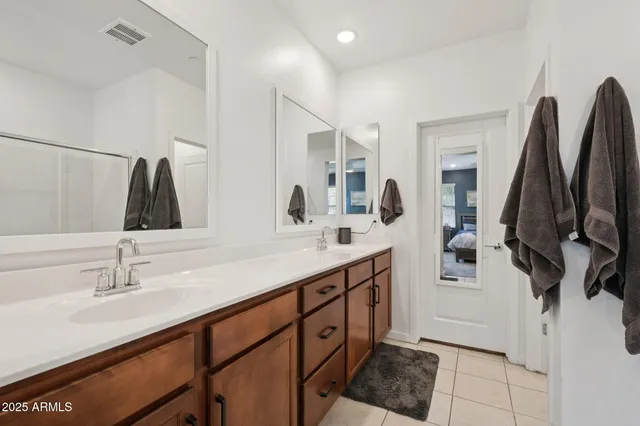 a bathroom with double vanity sink a mirror and shower