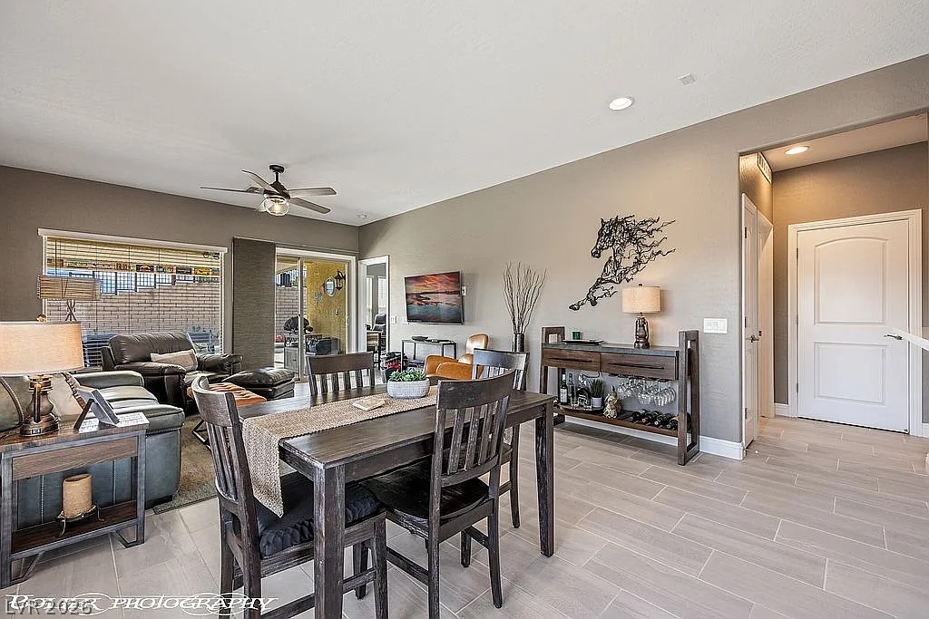 1304 Cottage Ridge Mesquite, NV 89034 - Photo 13 of 52 A well-lit, open-concept living and dining area features sleek tile flooring, offering both comfort and modern appeal.