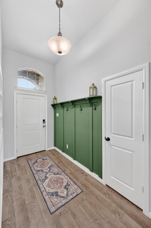 9604 Cherryville Road Fort Worth, TX 76108 - Photo 3 of 40 Entryway featuring wood-finish flooring and a built-in green accent wall with shelving and hooks