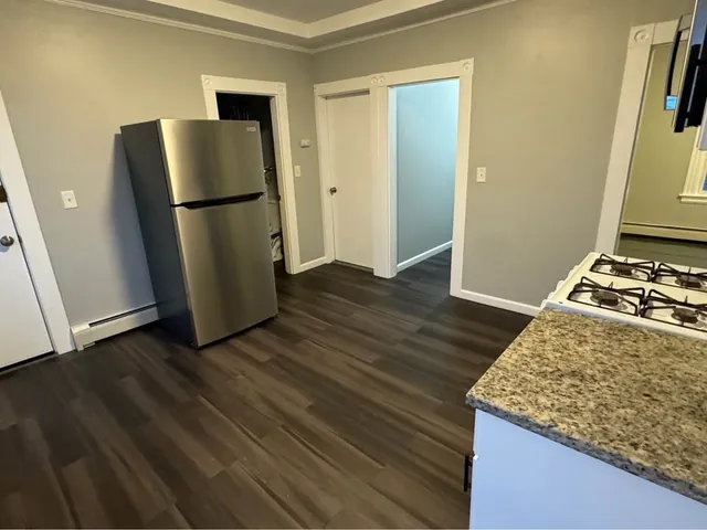 a kitchen with wooden floor and a refrigerator