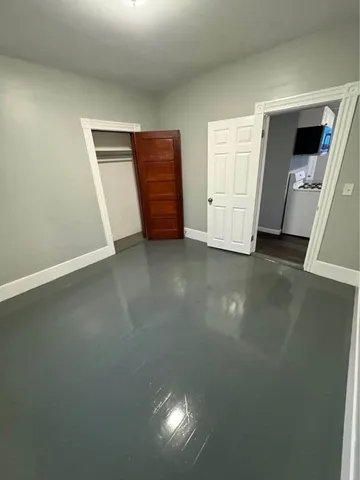 an empty room with closet and mirror