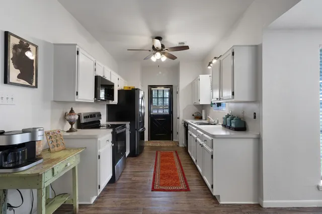 a kitchen with kitchen island granite countertop a sink cabinets and stainless steel appliances