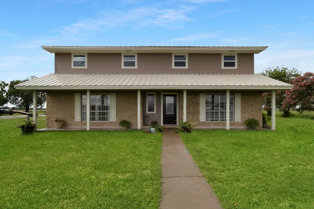 a front view of a house with a garden