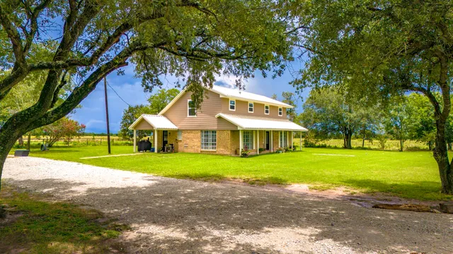a front view of a house with a yard and trees