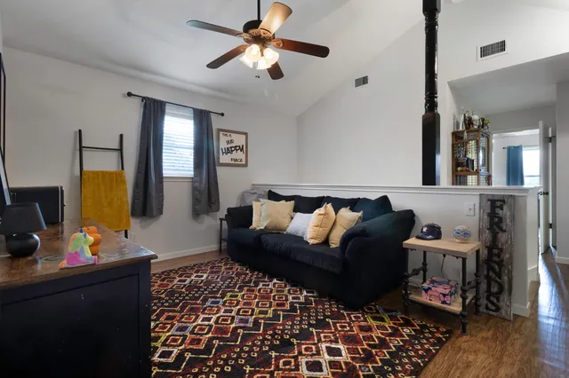 a living room with furniture a flat screen tv and a window