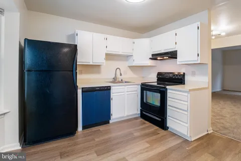 a kitchen with stainless steel appliances a refrigerator stove and white cabinets