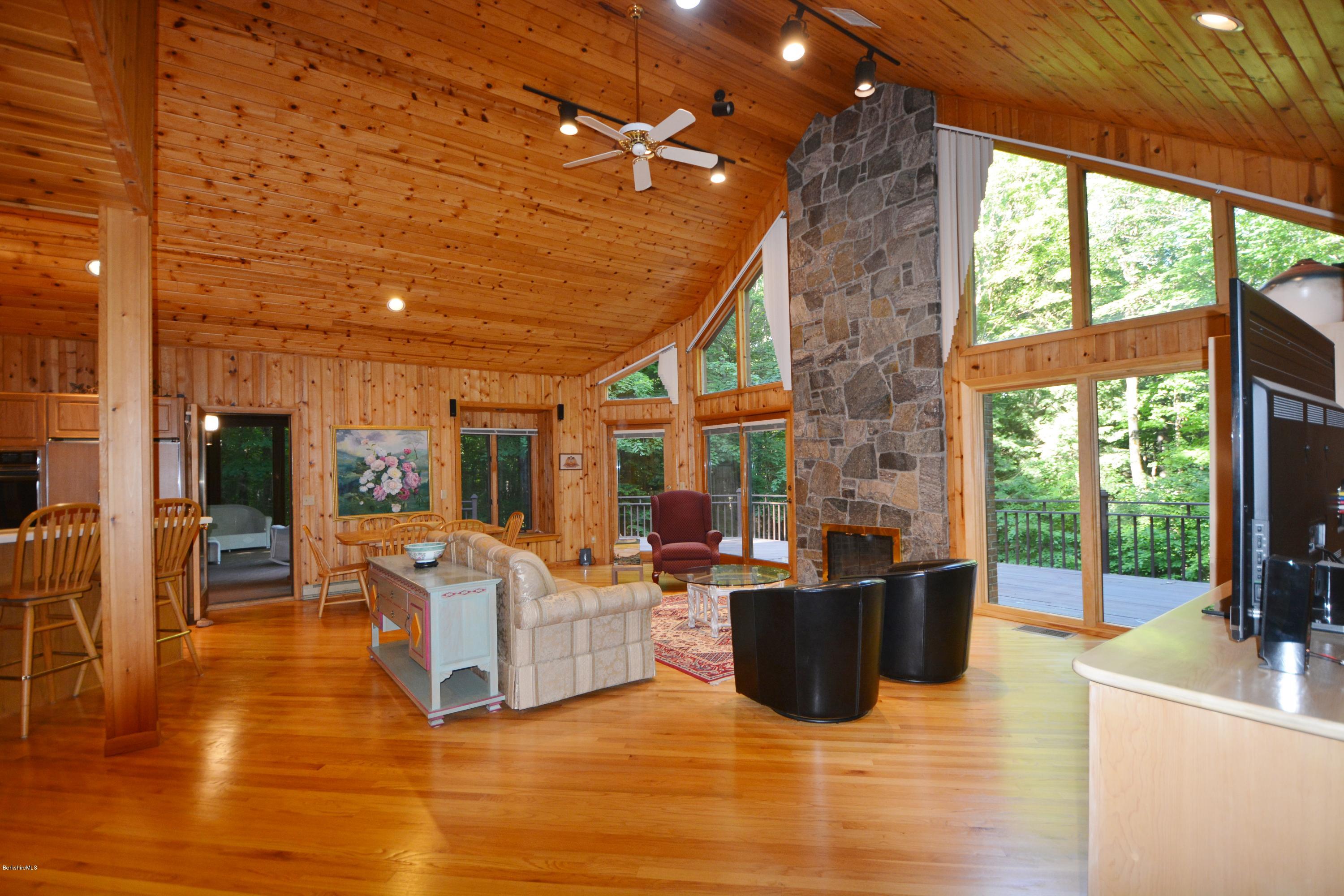 531 Moberg Road Becket, MA 01223 - Photo 3 of 25 a living room with furniture a flat screen tv and floor to ceiling windows