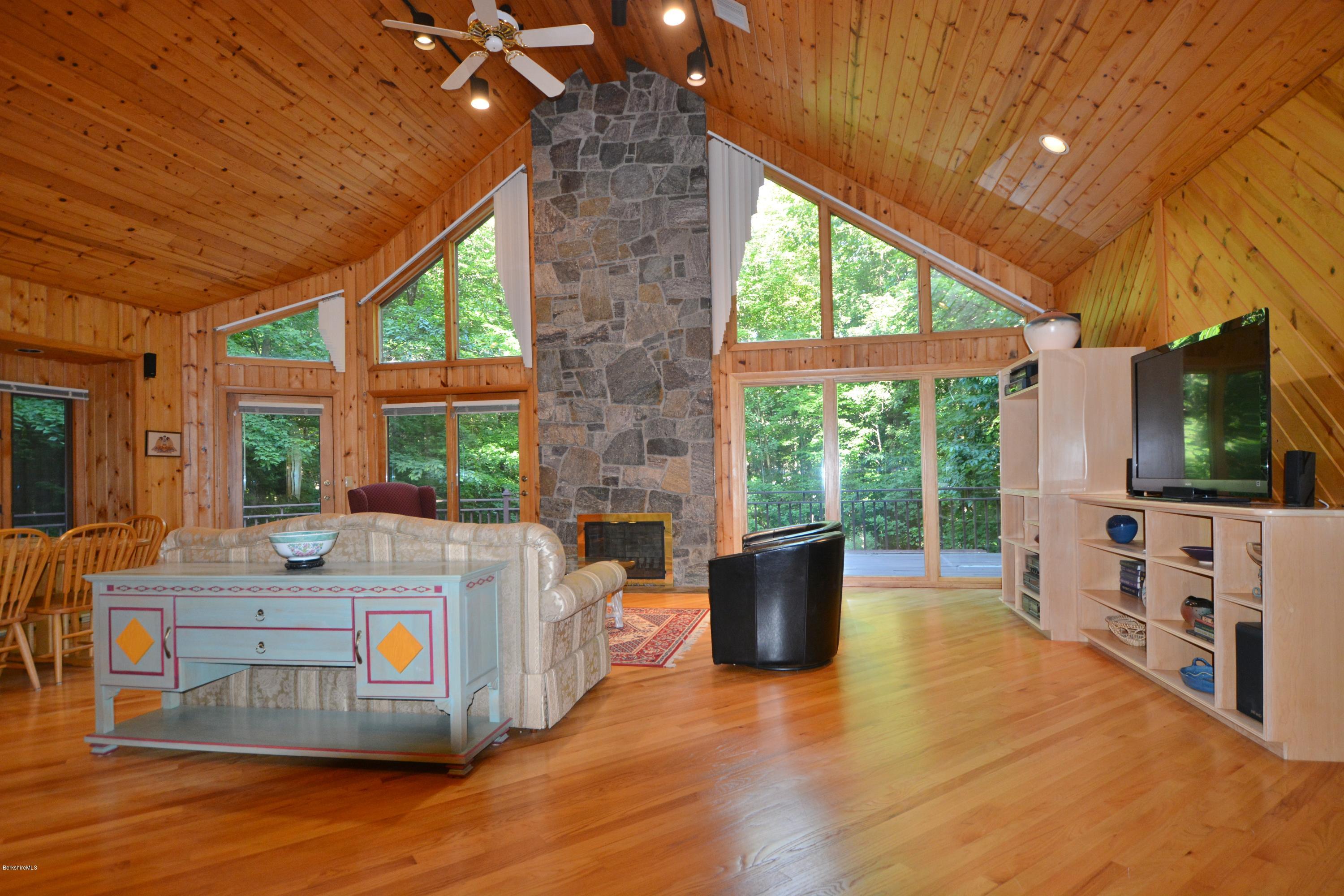 531 Moberg Road Becket, MA 01223 - Photo 5 of 25 a living room with furniture a flat screen tv and floor to ceiling window