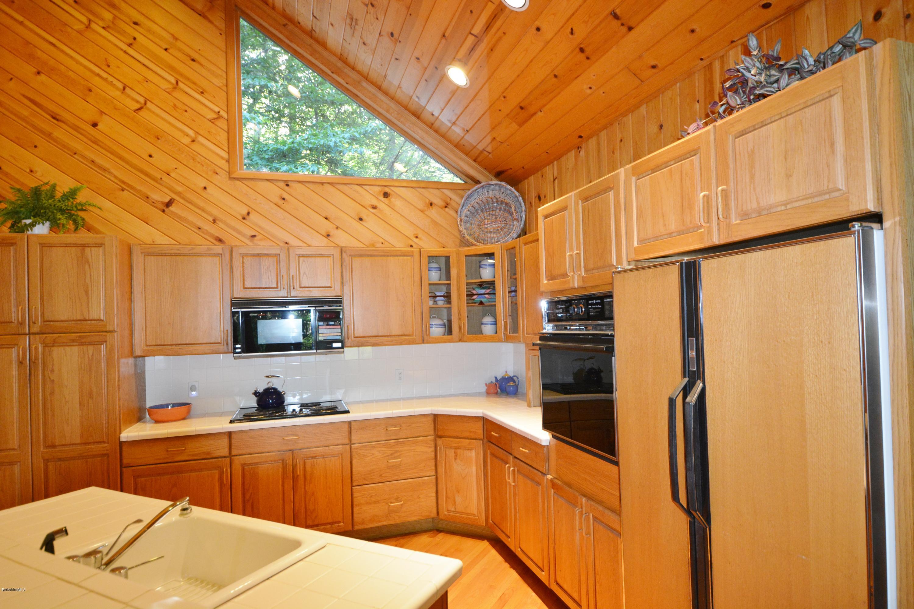 531 Moberg Road Becket, MA 01223 - Photo 8 of 25 a kitchen with stainless steel appliances a refrigerator sink and cabinets