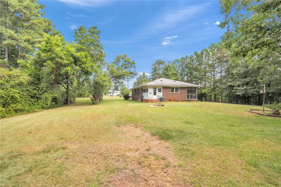 Mature trees frame a spacious lawn surrounding this brick residence.