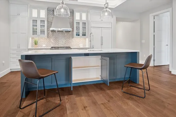 a kitchen with a table chairs and wooden floor