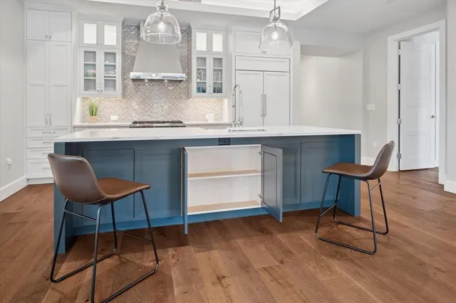 a kitchen with a table chairs and wooden floor