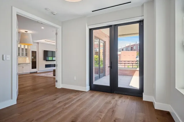a view of a big room with wooden floor and windows