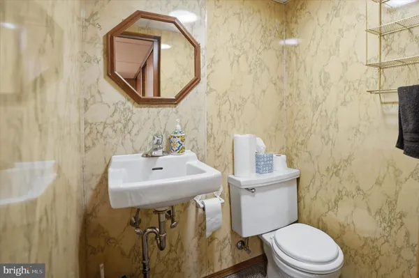 a bathroom with a toilet a sink and mirror
