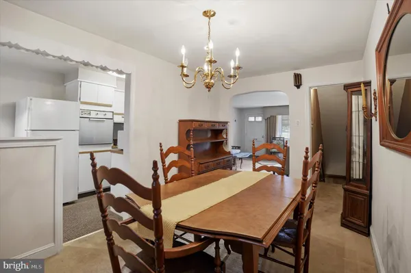 a view of a dining room with furniture a chandelier and wooden floor