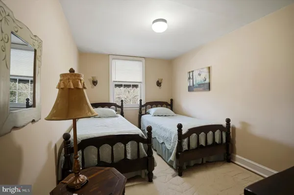 a bedroom with two beds and wooden floor