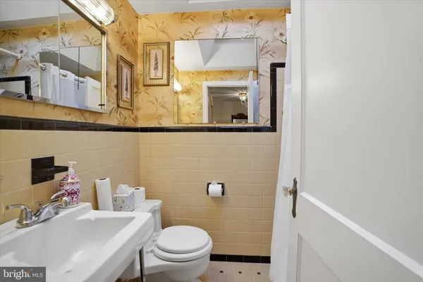 a bathroom with a sink a toilet and a mirror