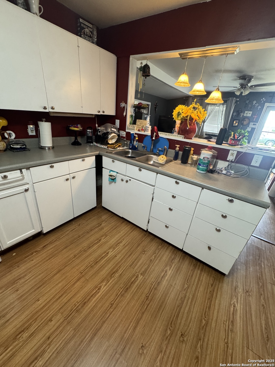 223 West Rio Grande Street Pearsall, TX 78061 - Photo 12 of 14 a kitchen with stainless steel appliances granite countertop a sink cabinets and wooden floor