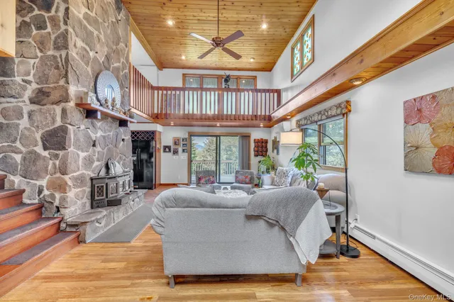 a living room with furniture a fireplace and a floor to ceiling window