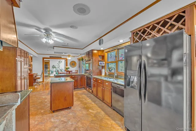 a kitchen with stainless steel appliances granite countertop a refrigerator a stove and a sink