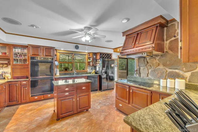 a kitchen with stainless steel appliances granite countertop a refrigerator a sink dishwasher a stove and a dining table with wooden floor