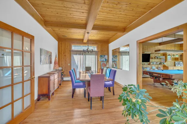 a dining room with furniture a chandelier and wooden floor