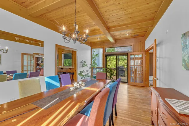 a view of a dining room with furniture a chandelier and wooden floor