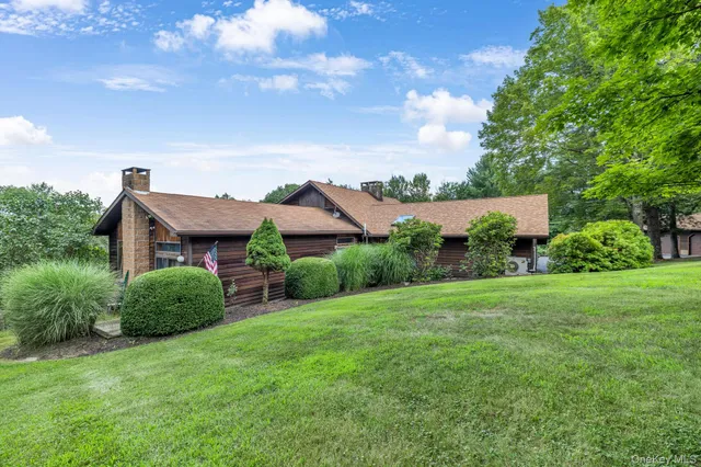 a view of a big house with a big yard and large tree