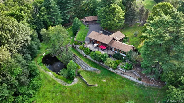 an aerial view of a house with swimming pool and red chairs