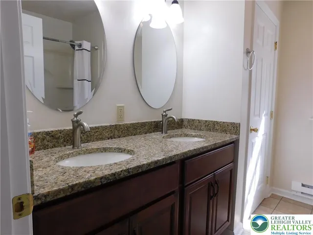 a bathroom with a granite countertop sink and a mirror