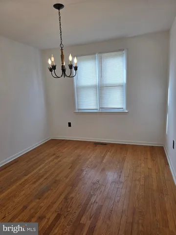 a view of a room with wooden floor and chandelier