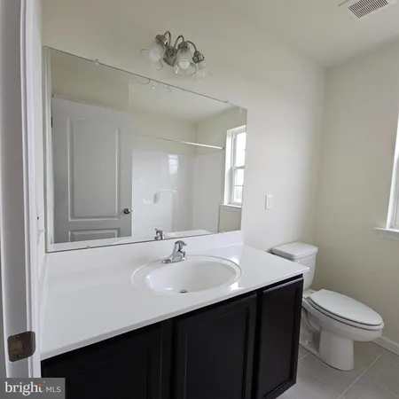 a bathroom with a sink a toilet and mirror