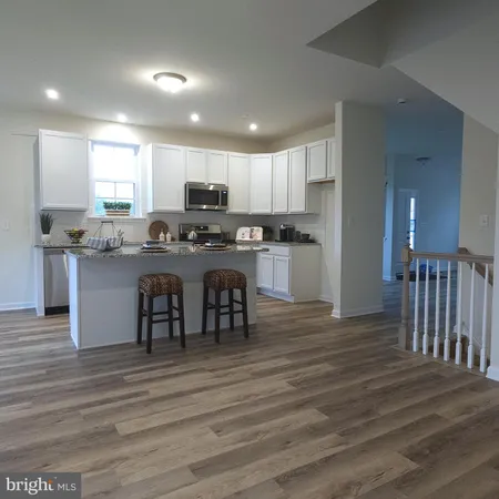 a kitchen with kitchen island granite countertop a sink and cabinets