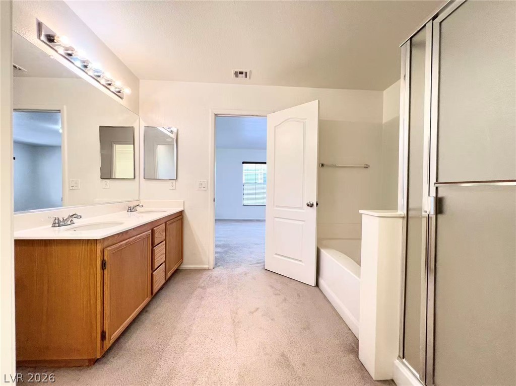 11143 Ranch Valley Street Las Vegas, NV 89179 - Photo 17 of 23 Double vanity and a walk-in shower provide convenience in this well-appointed bathroom.