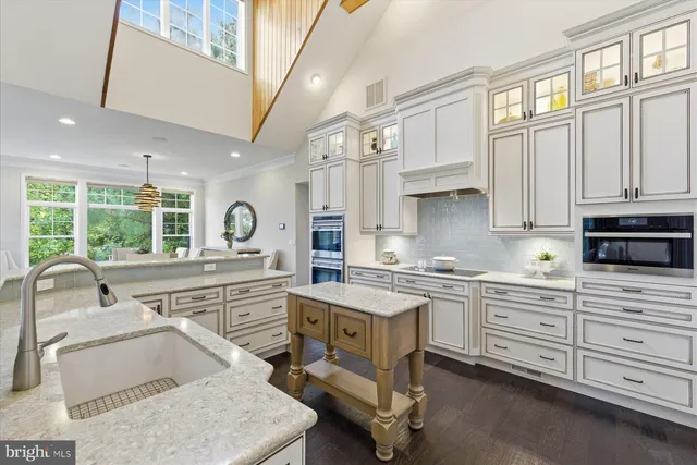 a bathroom with a granite countertop bathtub a sink and a window