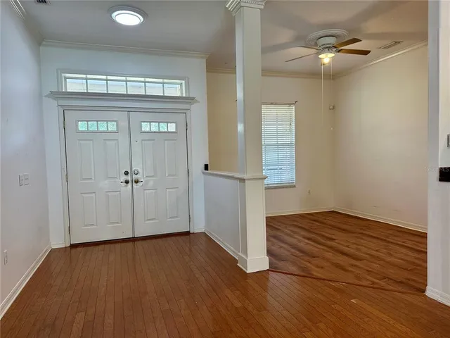 a view of living room with kitchen island stainless steel appliances furniture a fireplace and a chandelier