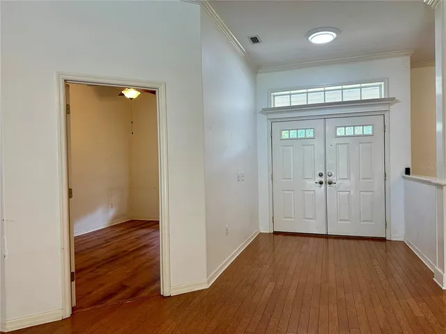 a large kitchen with kitchen island a stove a sink a refrigerator and a dining table with wooden floor