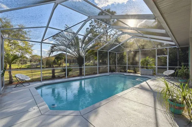 a view of a swimming pool with a patio and a yard