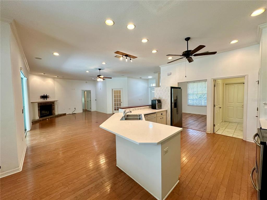 5261 Waterwood Drive Bartow, FL 33830 - Photo 21 of 72 a large kitchen with kitchen island a stove a sink a refrigerator and a dining table with wooden floor