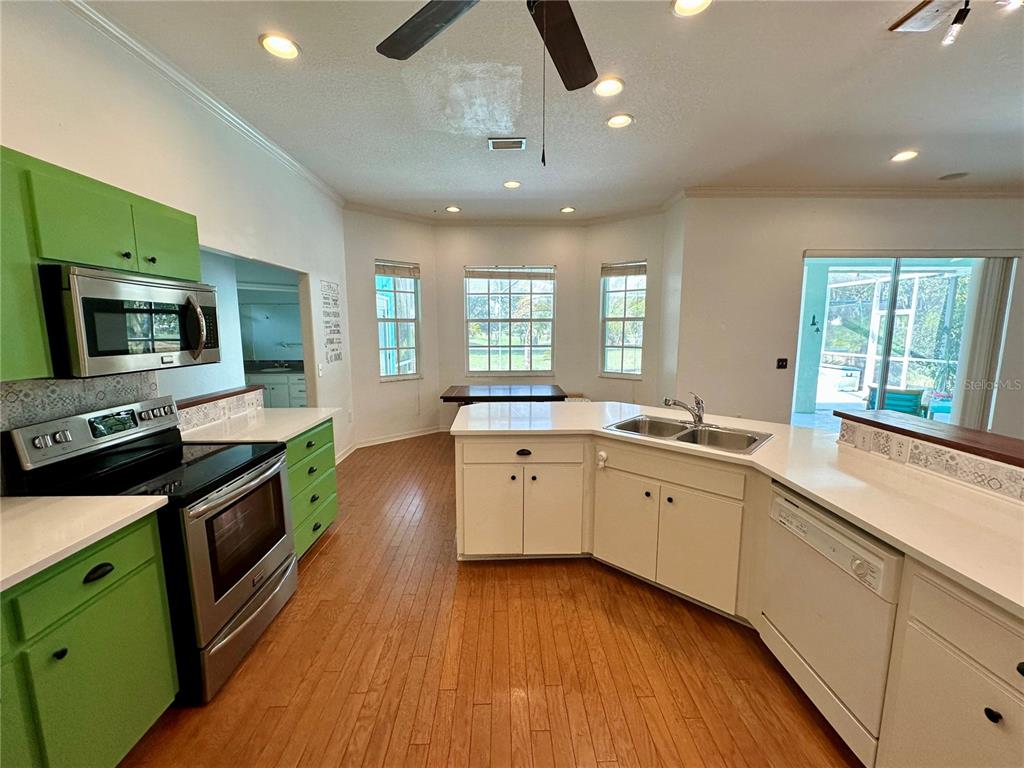 5261 Waterwood Drive Bartow, FL 33830 - Photo 24 of 72 a kitchen with granite countertop a stove top oven a sink dishwasher a dining table and chairs with wooden floor