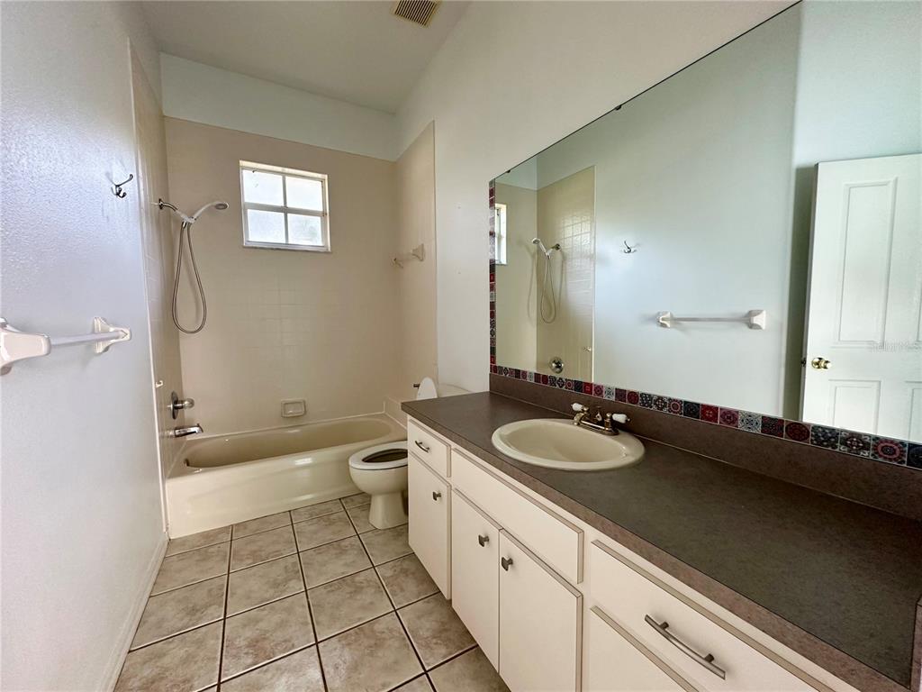 5261 Waterwood Drive Bartow, FL 33830 - Photo 35 of 72 a spacious bathroom with a granite countertop sink a toilet a mirror and shower