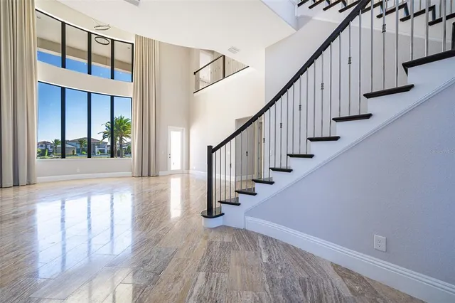 a view of a hallway with wooden floor and staircase