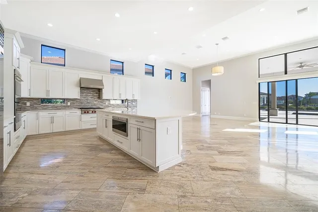 a large kitchen with stainless steel appliances granite countertop a stove a sink dishwasher and a refrigerator with wooden floor