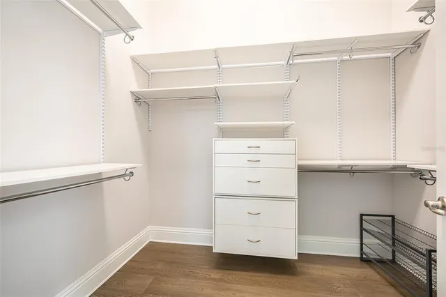 a view of a hallway with wooden floor and windows