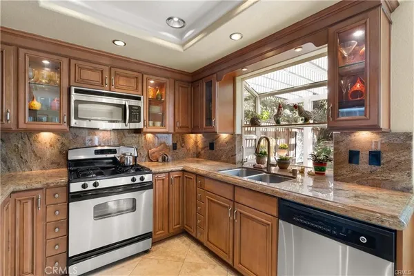 a kitchen with stainless steel appliances a stove sink microwave and cabinets