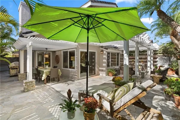 a view of a patio with chairs and umbrella
