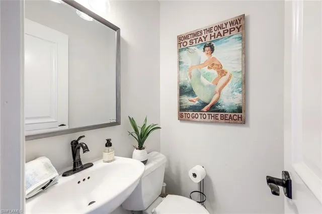 a bathroom with a sink mirror and toilet