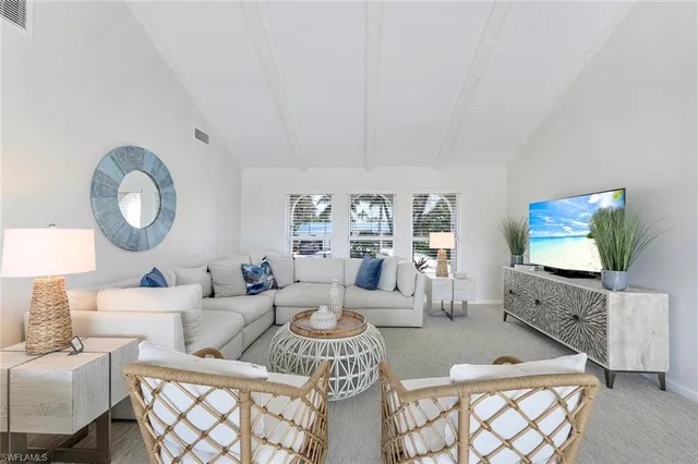 a living room with furniture a mirror and a flat screen tv